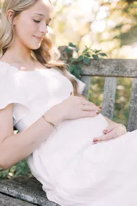 mom holding belly in Peoria Illinois maternity photos at Luthy Botanical Gardens