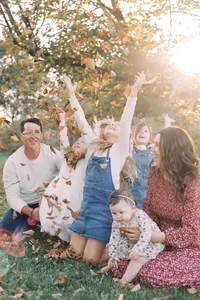 family throwing leaves at sunset in donovan park in peoria il family photos