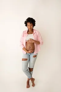 Brandy gazing down at belly during timeless studio maternity session
