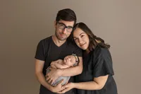 portrait of mom and dad holding newborn