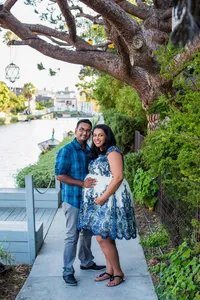 expecting couple holding each other during outdoor maternity portrait session in Venice Beach, California