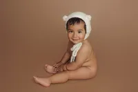newborn in knit cap, brown backdrop during studio portrait session in North Hollywood