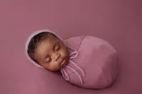 newborn Aubrey on magenta backdrop during studio portrait session in Los Angeles