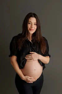 expecting mom with hands cradling bump during intimate maternity portrait session