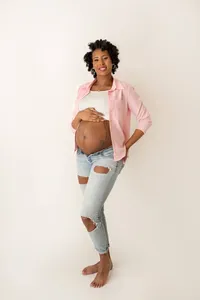 pregnant mom holding baby bump in casual, classic studio maternity photoshoot