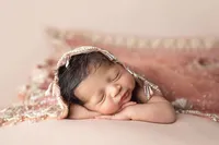 close-up portrait of sleeping newborn with pink textured backdrop during luxury newborn session at CG Photography