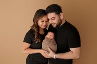 mother and father cradling newborn baby during luxury photoshoot in Los Angeles