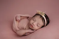 newborn in pink wrap and headband during fine art studio portrait session in North Hollywood