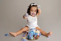 baby Violet playing with cake during fine art milestone portrait session at CG Photography North Hollywood