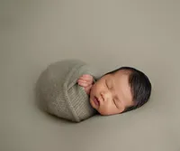 sleeping newborn in organic wrap during luxury newborn session in Los Angeles