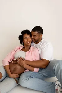 candid moment of expecting couple holding each other tenderly in studio portrait for maternity photoshoot