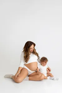 mother-to-be gazing down at belly during intimate studio maternity session