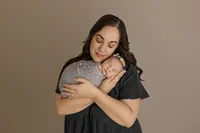 mother cradling newborn during studio photoshoot in North Hollywood
