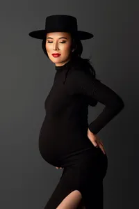 expecting mother in black dress during classic and elegant maternity photography session in North Hollywood studio
