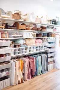Studio shelves organized with baskets, posing props, fabric, and blankets for portrait sessions.