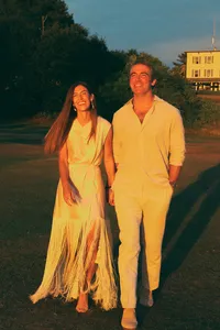 Couple walking together at golden hour, bride in a flowing yellow dress