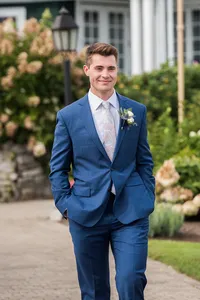 Groom in a navy suit and white boutonniere in the garden at French's Point, Stockton Springs, Maine