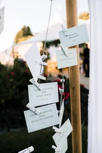 Hanging escort card tags tied with ribbon at Patty and Cooper's coastal Maine wedding