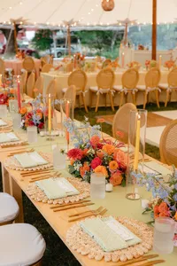 Tablescape with candles, colorful florals and rattan chargers