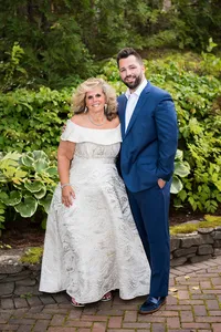 Groom smiling with a guest in the garden at French's Point