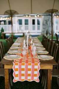 Long table with an orange checkered runner under the tent