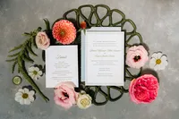 Wedding invitation suite styled with pink garden roses and green florals
