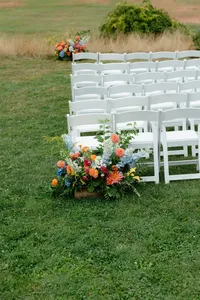 Ceremony chairs on the lawn framed by bright floral arrangements