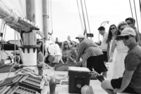 Black and white photo of guests aboard a sailboat