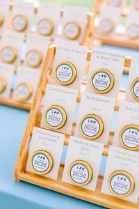 Rows of personalized jar favors with blue lids for guests