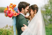 Bride and groom share a quiet moment with her colorful bouquet