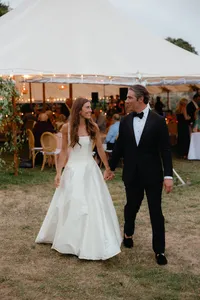 Bride and groom walk into the tented reception