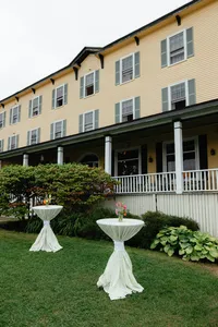 Chebeague Island Inn porch with white cocktail tables on the lawn