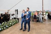 Grooms walking into the reception tent