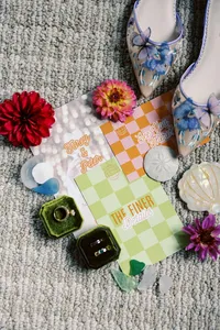 Wedding details with colorful rings, florals and checkered stationery