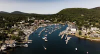 Aerial view of Camden Harbor in Maine filled with sailboats on Patty and Cooper's wedding weekend