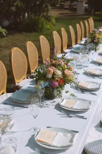 Long outdoor reception table set with candles and greenery