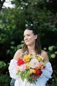 Bride smiling with a bright summer bouquet