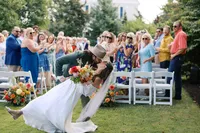Bride dipped by the groom as guests cheer