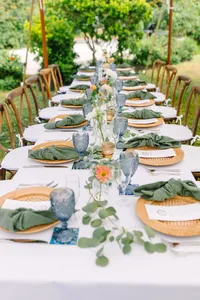 Long table with eucalyptus garland and blue goblets
