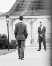 Black and white first look as the grooms meet on the lawn at French's Point