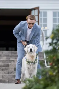 Groom with a golden retriever on the porch