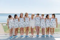 Bridesmaids in floral dresses lined up on the waterfront terrace
