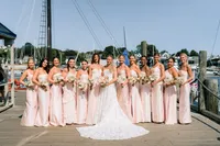 Bridal party in blush gowns with the bride by the harbor in Rockport, Maine