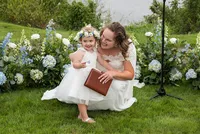 Flower girl sitting on the lawn by the ceremony
