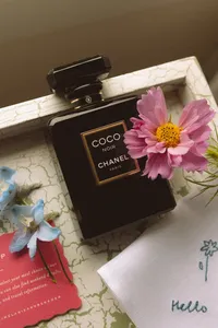 Wedding day details with perfume, pressed flowers and a handwritten note
