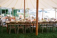 Sailcloth tent reception with long wooden tables