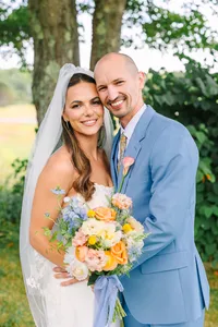 Bride and groom smiling together with her pastel bouquet