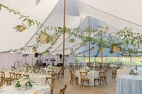 Reception tables under garlands of greenery in the tent