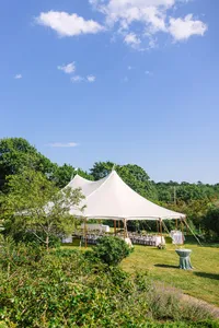 Sailcloth tent set beside the trees above the water