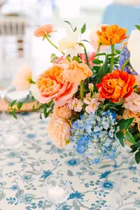 Coral and blue centerpiece on a floral printed tablecloth